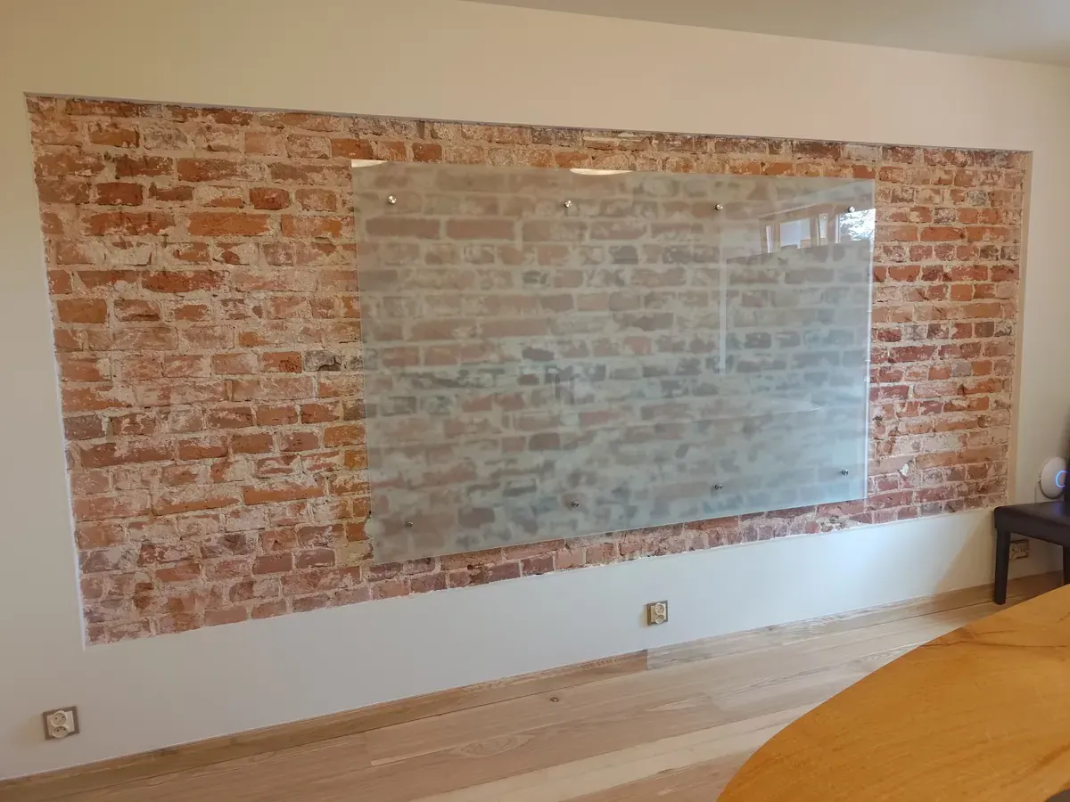 duża tablica szklana suchościeralna na ceglanej ścianie w biurze